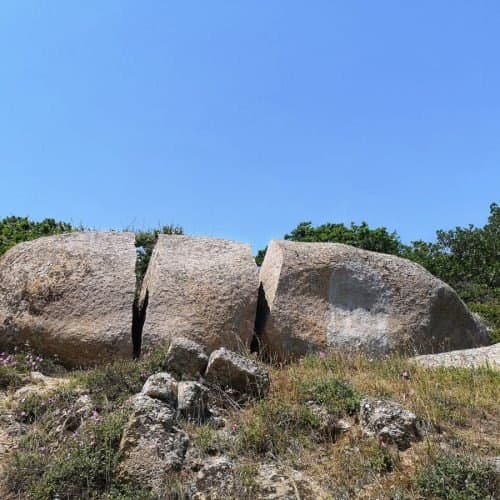 Скалата, разчленена на три части, на брега